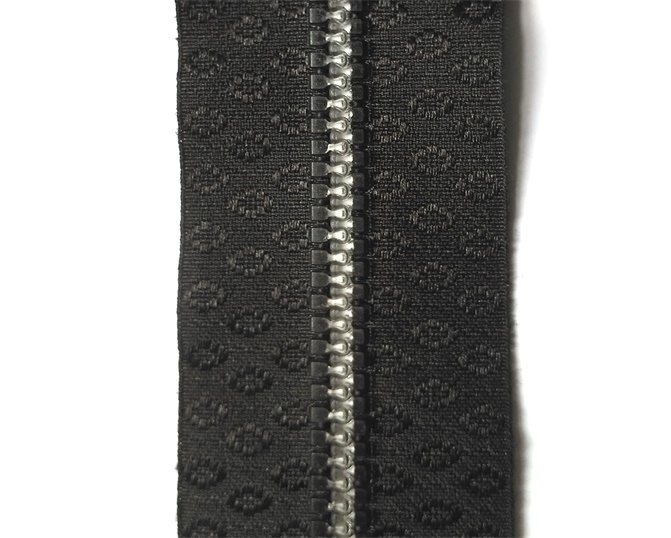 Plastic zipper with dots-designed tape